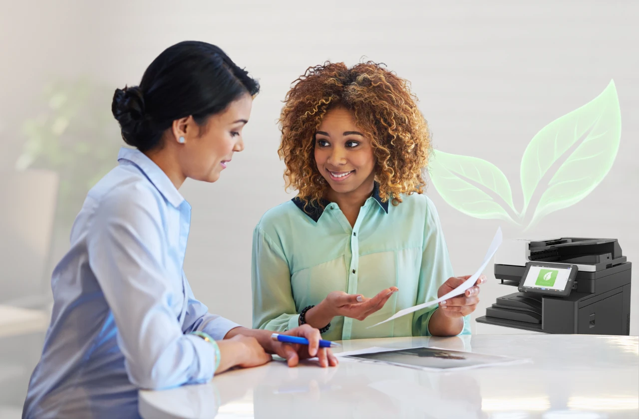 Two people at an office desk reviewing printed documents, with a printer and green leaf graphic for sustainable printing.