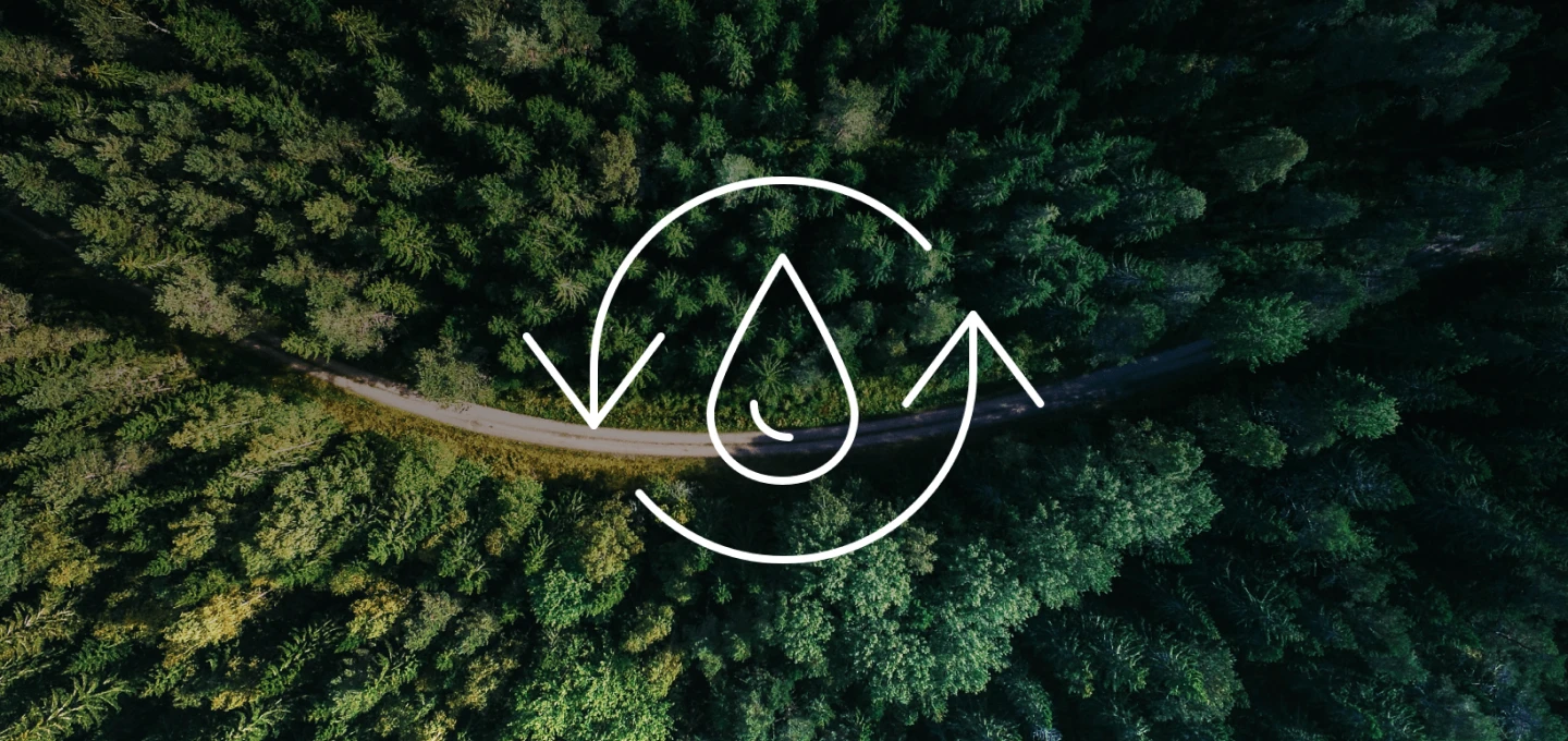 A water droplet with arrows pointing up and down, over an aerial view of a forest.